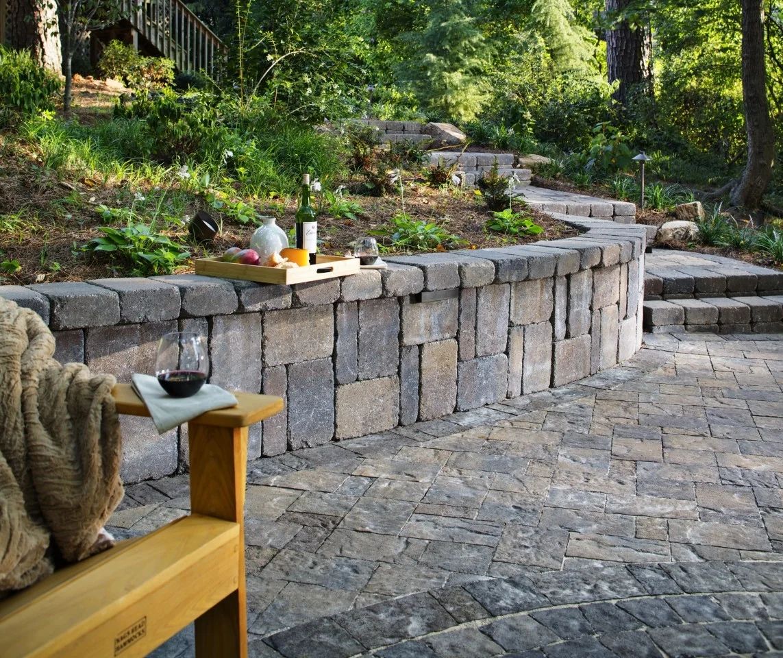 Finished stone walkway and garden steps beside a curved masonry wall
