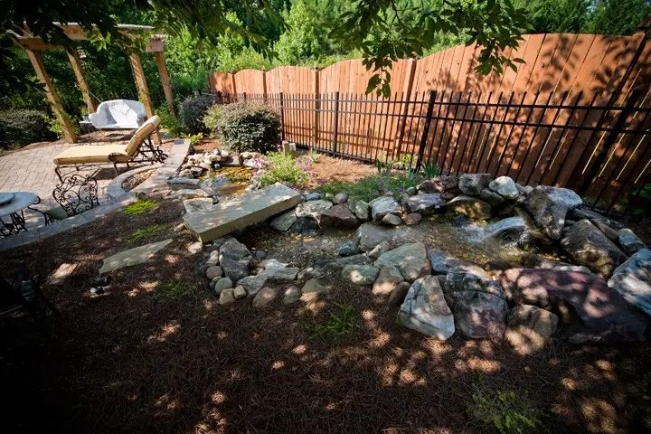 Garden pond with natural boulders and a small waterfall