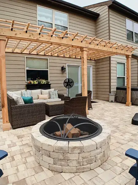 Cedar pergola over patio with fire pit and Adirondack chairs