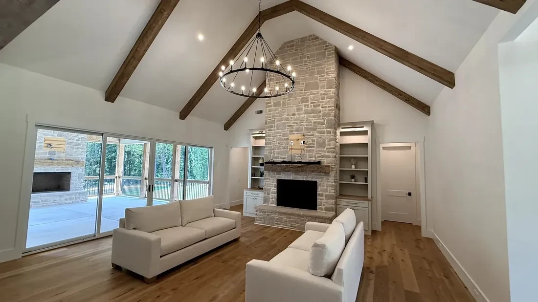 Great room with stone fireplace and vaulted beams in a Southern Pines custom home near Jefferson, GA