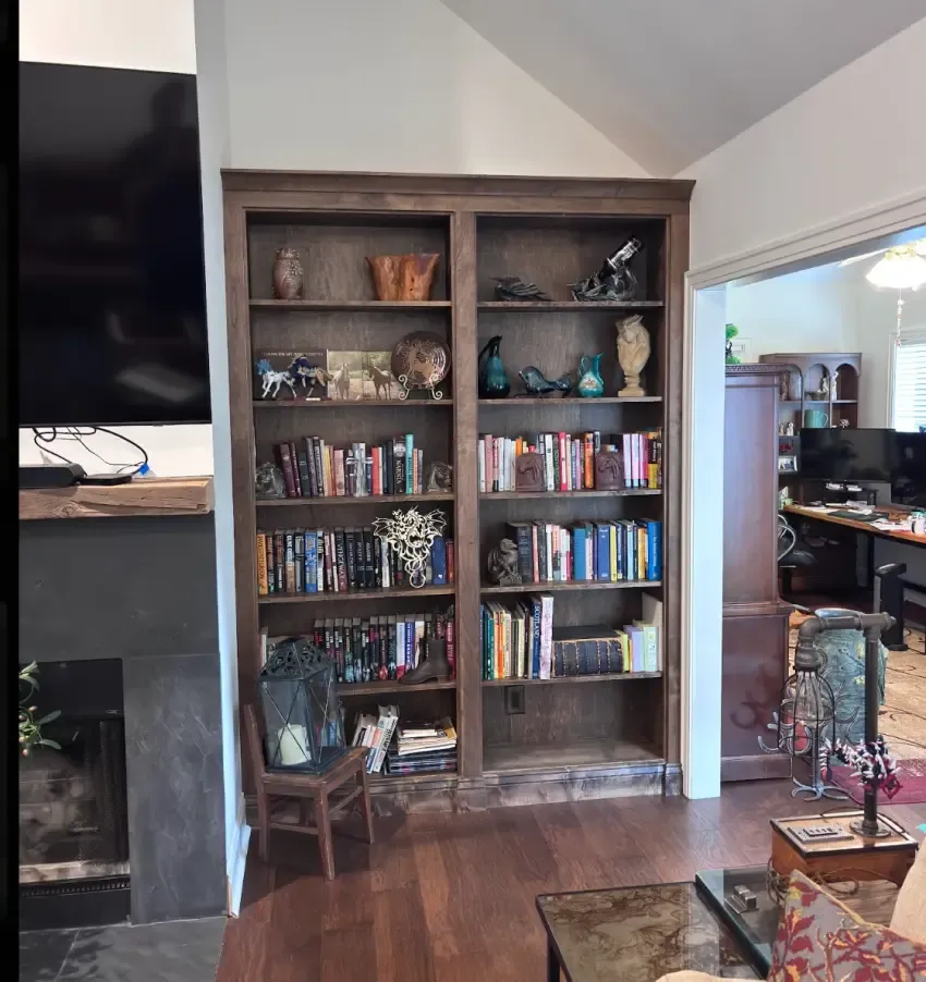 Full-height stained wood bookcase filled with books