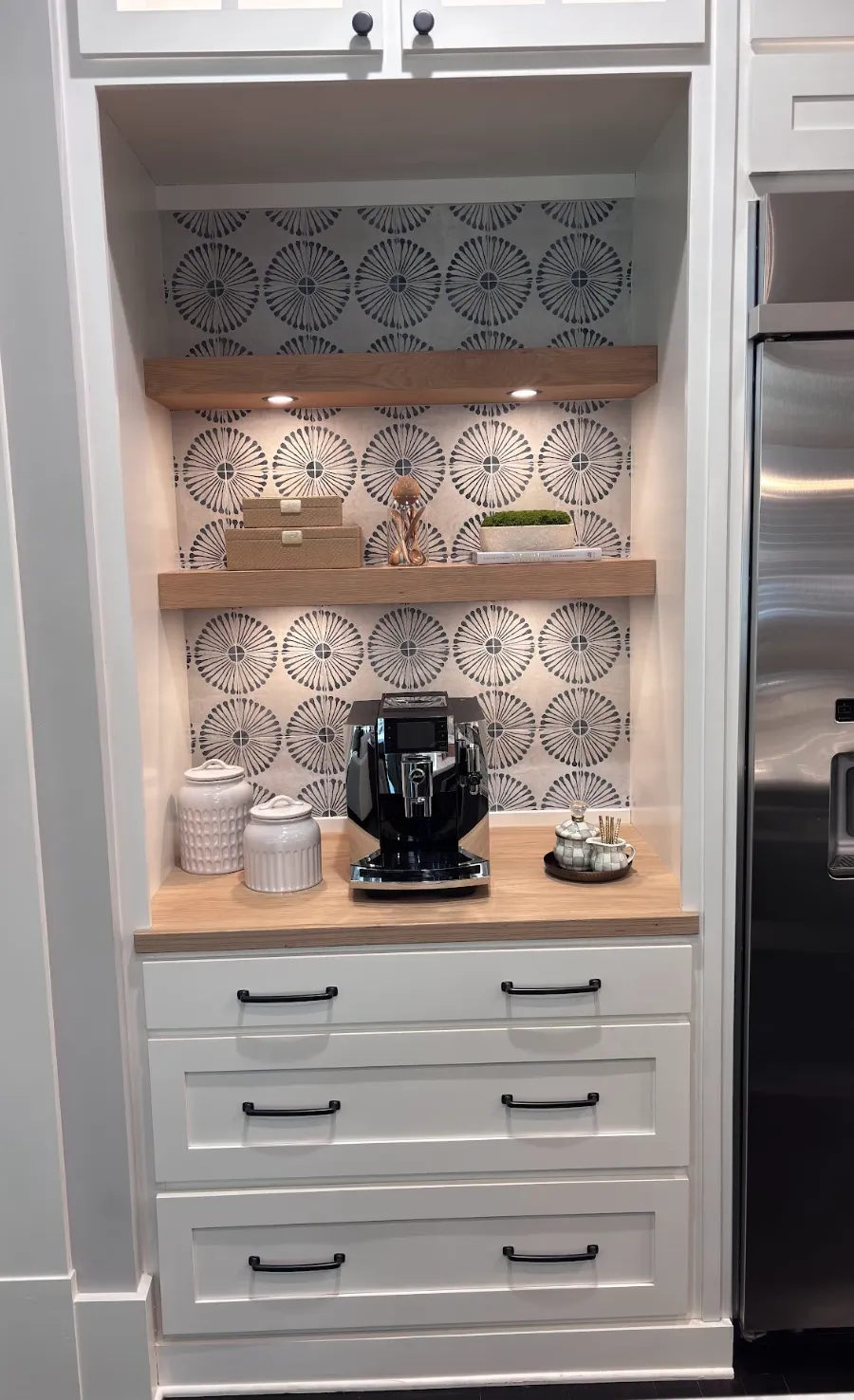 Built-in white coffee station with wood countertop and display shelving