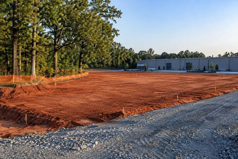Prepared commercial ground with retained vegetation and site infrastructure