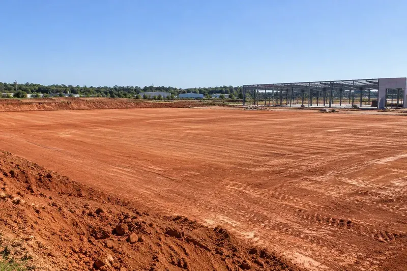 Prepared commercial ground with retained vegetation and site infrastructure